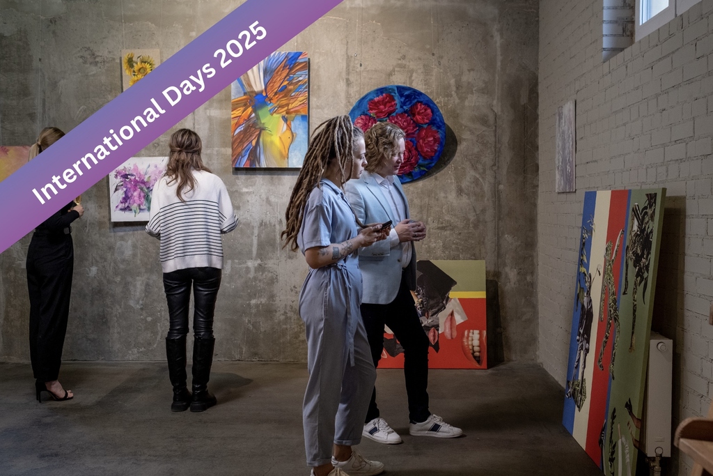Menschen betrachten Kunstwerke in einer Galerie, Banner: International Days 2025.