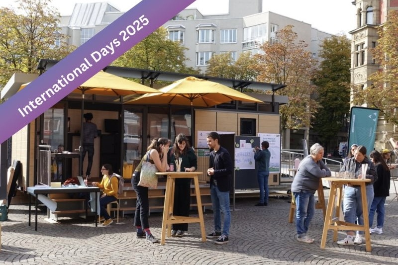 Menschen bei den International Days 2025 an Stehtischen im Freien.