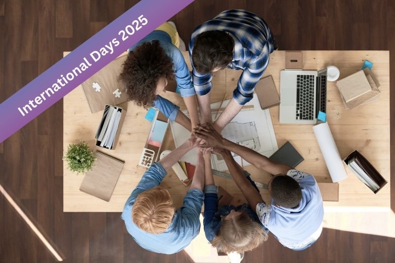 Menschen legen die Hände übereinander am Tisch, "International Days 2025".