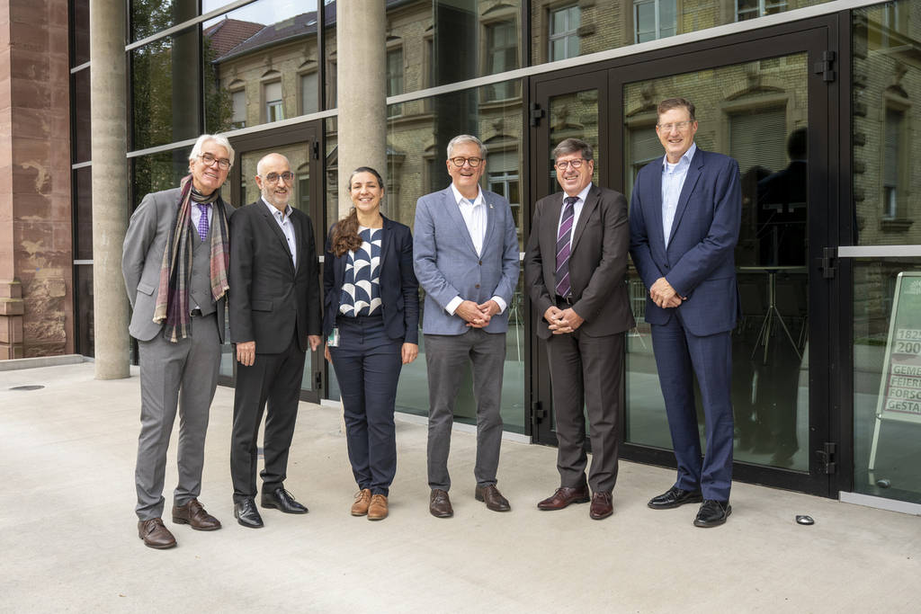 6 Menschen von zwei Unis bei einem Treffen in einer Reihe
