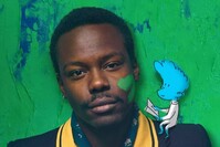 Porträt einer Person vor grün-blauem Hintergrund mit kleiner blauer Comicfigur auf der Schulter.